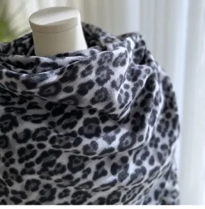 Close-up detail of grey leopard print winter scarf, soft imitation cashmere texture.