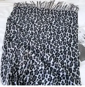 Detailed view of the classic black and white leopard print cashmere-feel tassel scarf.