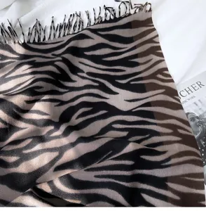 Close-up detail shot of a stylish autumn and winter zebra print fringe scarf texture.