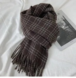 Vue détaillee de l'echarpe a carreaux marron d'hiver avec franges, tissu chaud.