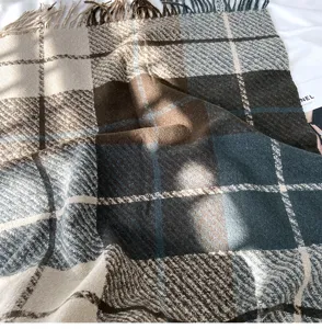 Detailed shot of a cozy plaid tassel scarf with soft texture and rich color blend.