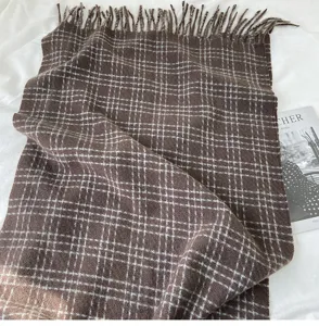 Écharpe d'hiver à carreaux marron confortable, accessoire doux et chaud avec des franges stylées.