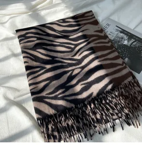 Detailed close-up view of the autumn winter women zebra print cashmere feel scarf with fringe.