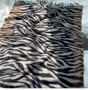 Detail view of the autumn winter imitation cashmere scarf featuring stylish zebra print and chic tassels.