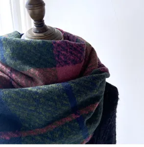 Close-up detail of the thick plaid winter scarf, showcasing soft cashmere-feel fabric.