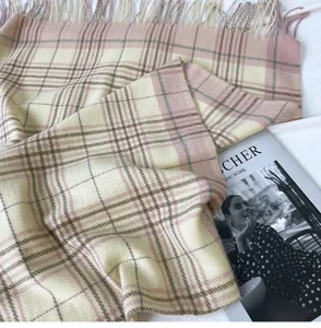 Vista dettagliata della sciarpa con frange a quadri rosa autunno inverno donna, accessorio moda.
