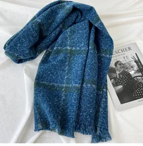 Close up view of blue green plaid cashmere feel tassel scarf cozy winter neck accessory
