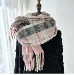 Close-up detail of soft pink plaid tassel scarf, cozy cashmere feel winter neck wrap.