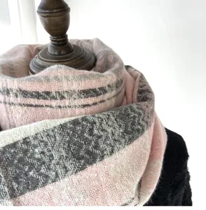 Close-up detail view of the soft pink and grey plaid cashmere-feel winter scarf design.