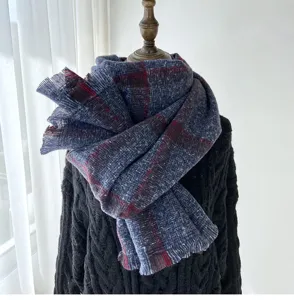 Detail shot of cozy plaid fringe scarf in blue and red, soft texture for autumn and winter style.