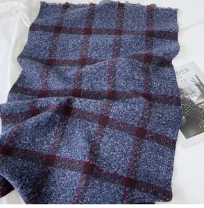 Detailed close-up of a blue plaid winter scarf with red checkered pattern and soft fringe.