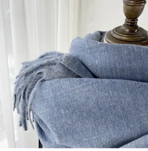 Detailed close-up view of a soft blue cashmere-feel winter scarf showcasing delicate fringe texture.