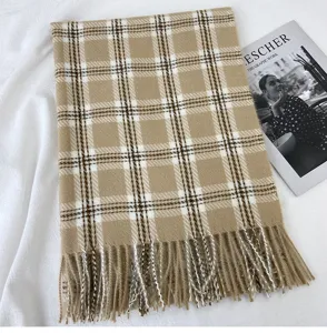 Detail view of a classic plaid winter scarf, soft imitation cashmere with stylish fringe edges.