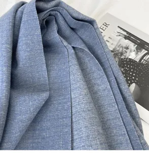 Close-up of soft blue textured winter scarf showing detailed fabric grain and cozy warmth.