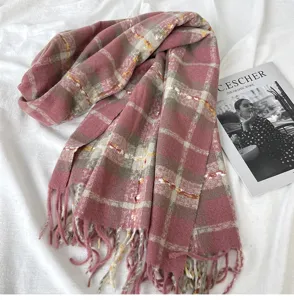 Detail view of the cozy pink plaid tassel scarf, showcasing soft texture and classic grid pattern.
