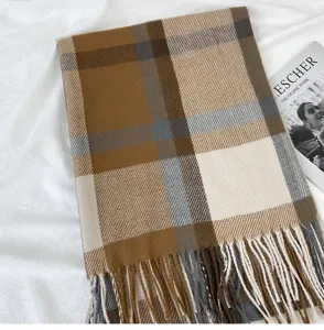 Close-up detail of the stylish plaid winter scarf, highlighting soft texture and fringe design.