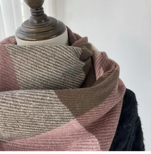 Detailed view of winter warm plaid scarf texture, soft fabric with cozy brown and pink tone.