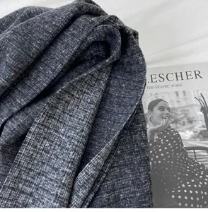 Close-up detail of the dark grey cashmere-feel winter scarf, showing soft woven texture.