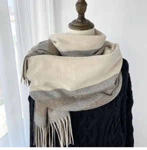 Detail view of cozy winter plaid scarf with fringe, soft fabric, elegant draped styling.