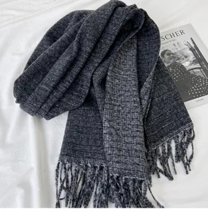 Detailed view of a dark grey cashmere-feel winter scarf with elegant fringe texture and soft drape.