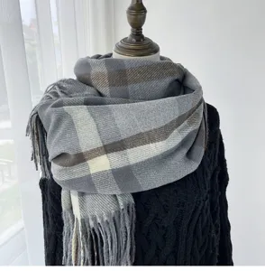 Detail view of the winter plaid scarf showcasing classic check pattern and soft tassel texture.