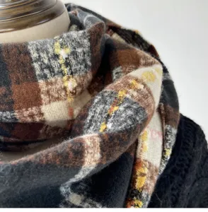 Chunky winter plaid scarf detail, soft imitation cashmere fabric, warm neck wrap in brown hues.
