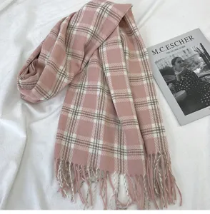 Detailed view of soft pink plaid scarf with fringe, cozy winter cashmere feel accessory.