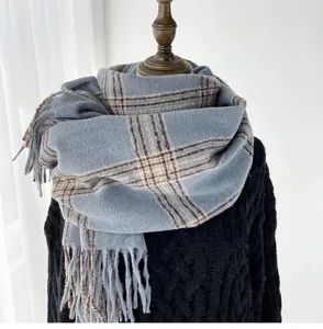 Detailed view of the cozy blue plaid scarf with classic tassels, perfect for cold winter days.
