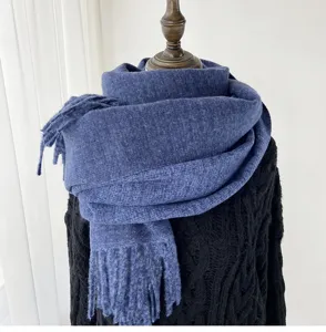 Blue cashmere-feel winter scarf detail showing soft textured knit fabric and fringe ends.