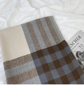 Detailed shot of a cozy cashmere-feel color-block plaid winter scarf with soft warm texture.
