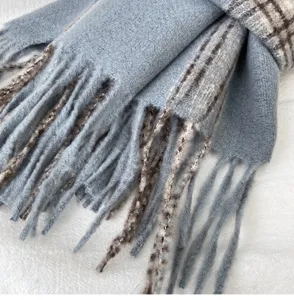 Close up detail of soft blue plaid tassel scarf texture winter warm accessory.