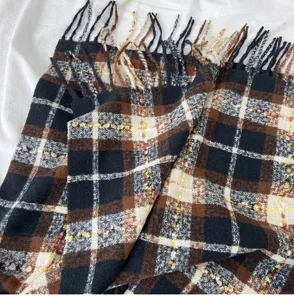 Detailed view of winter plaid scarf, soft tassel shawl, warm check pattern for cold weather.