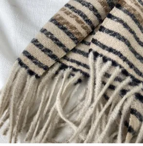 Close-up detailed view of winter striped fringe scarf texture, soft warm cashmere fabric.