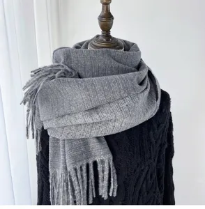 Detailed view of soft grey winter tassel scarf, cozy cashmere feel accessory for cold weather