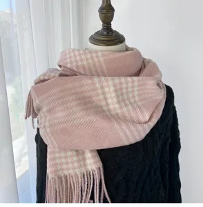Detailaufnahme des rosa-weißen Hahnentritt Schals für den Winter mit weichen Fransen.