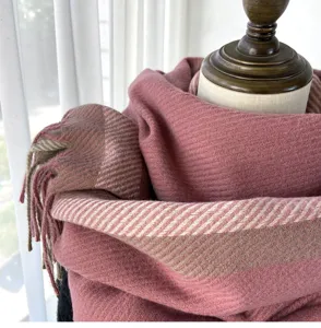 Close-up detail of women winter warm herringbone plaid scarf with tassel, soft cashmere feel.