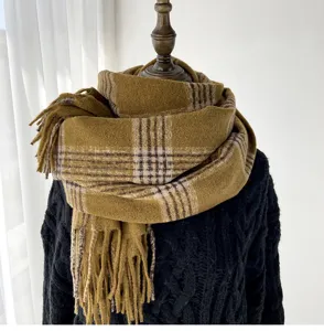 Detail shot of a cozy winter plaid scarf with fringe, soft warm fabric texture.