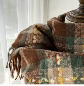 Cozy winter plaid scarf detail, classic brown and green pattern with soft fringe, warm texture.