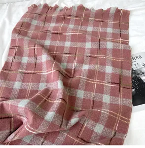 Detailed view of winter retro plaid scarf with fringe, soft warm woven fabric texture.