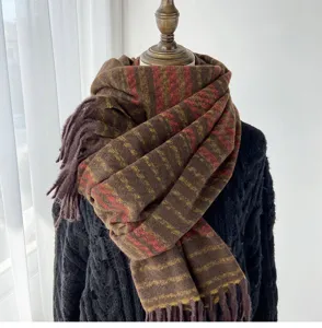 Cozy winter tassel scarf detail shot, warm imitation cashmere material with autumn brown stripes.