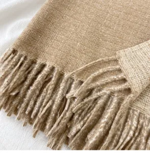 Detailed view of a stylish camel brown faux cashmere fringe scarf, warm winter accessory.