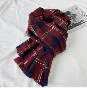 Detailed shot of a cozy winter plaid scarf in classic red and blue, featuring soft fringes.