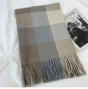 Detailed view of the cozy plaid scarf with classic color blocking and fringe trim.