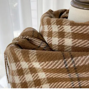 Close-up detail of brown plaid cashmere-like winter scarf showing soft textured fabric.