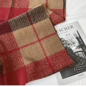 Close-up detail of soft autumn and winter plaid scarf, cozy warm fabric texture.