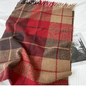 Detailed view of a cozy imitation cashmere plaid tassel scarf in red and brown tones.