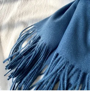 Detailaufnahme der weichen blauen Kaschmirimitat Winterschal Textur mit eleganten Fransen.