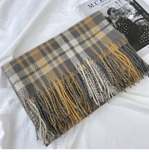 Close-up detail of a cozy grey and yellow plaid cashmere-feel winter scarf with elegant tassels.