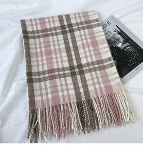 Detailed close-up view of a thick winter plaid scarf in pink and brown with elegant fringe.