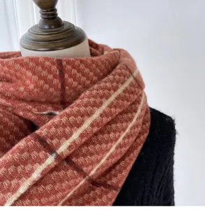 Close-up detail of the cozy imitation cashmere plaid scarf texture, soft warm winter accessory.